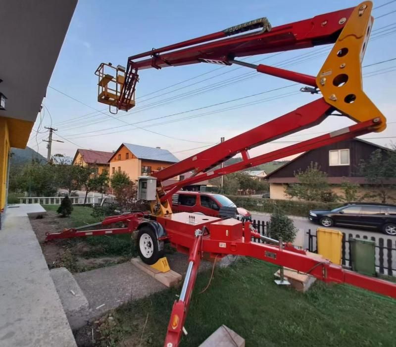 LIFTSGLT towable boom lift with outriggers deployed for private estate exterior maintenance LIFTSGLT towable boom lift with outriggers deployed for private estate exterior maintenance